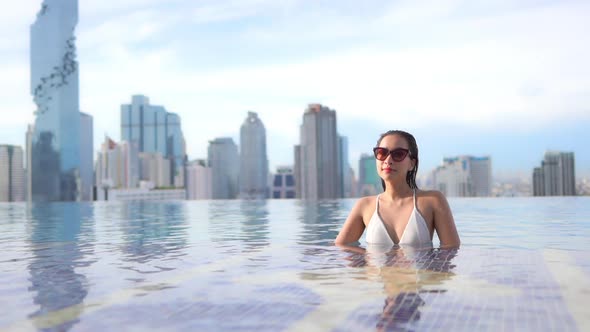 Young asian woman enjoy around outdoor swimming pool for leisure