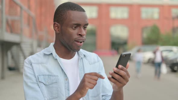 Outdoor African Man Celebrating on Smartphone