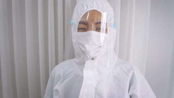 Medical Worker in Full PPE Kit Uniform with Hand Gloves During Covid19 Outbreak Swab Testing Patient