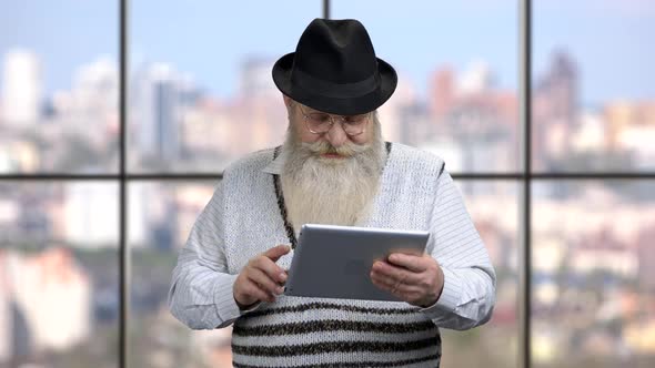 Smiling Senior Man Holding Computer Tablet
