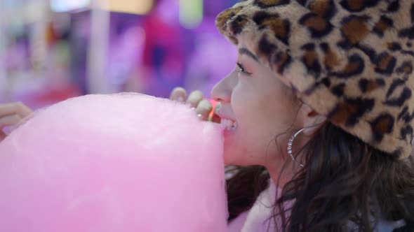 Face of Cute Young Female Biting Sticky Pink Colour Candy Floss in Funfair Park