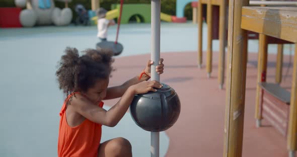 Adorable Afro Little Girl Having Fun Climbing Metal Stairs at Children Modern Playground