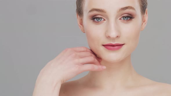 Studio portrait of young, beautiful and natural woman over grey background.