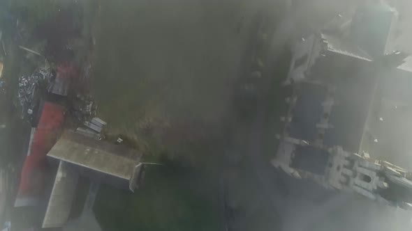 Aerial of rural village with church covered in mist, Poland, Chochołów