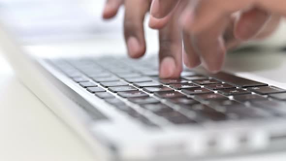 Front View of Fingers of African Man Typing on Laptop Keyboard 