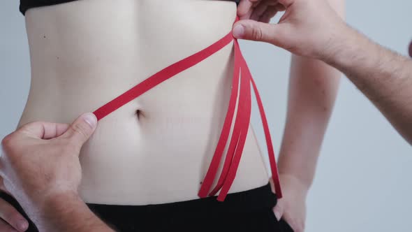 Person with Red Kinesiology Tape on Stomach in Private Clinic