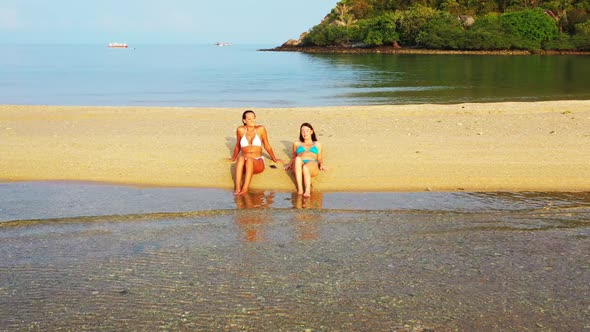 Ladies together look beautiful on marine bay beach voyage by blue green water and white sand backgro