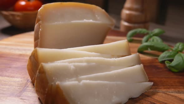 Semihard Sheep Cheese Cut in Triangular Pieces Laying on the Wooden Board