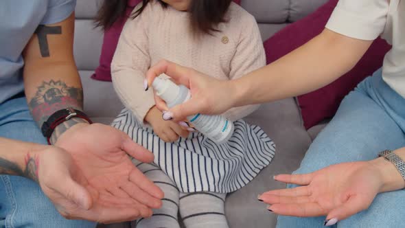 Closeup of Family Disinfecting Hands with Antiseptic
