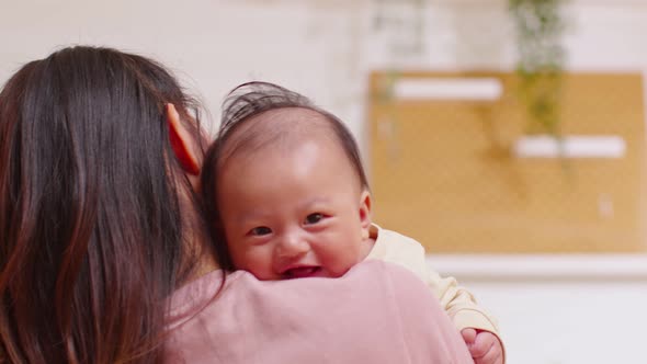 Close up face of adorable newborn baby smile and laughing in mother arm safety and comfortable