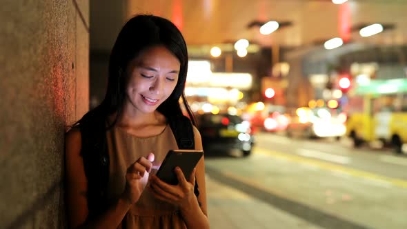 Woman use of smart phone in city at night 