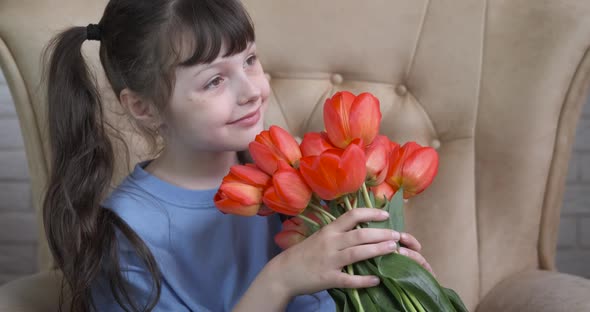 The child sniffs flowers. 