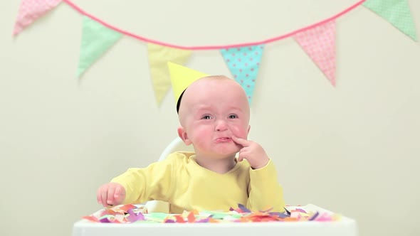 Baby boy sitting in highchair with bunting