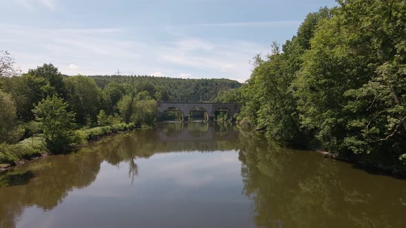 Old brick train trestle leading over the Sieg river near Schladern, Germany on a sunny spring day. L