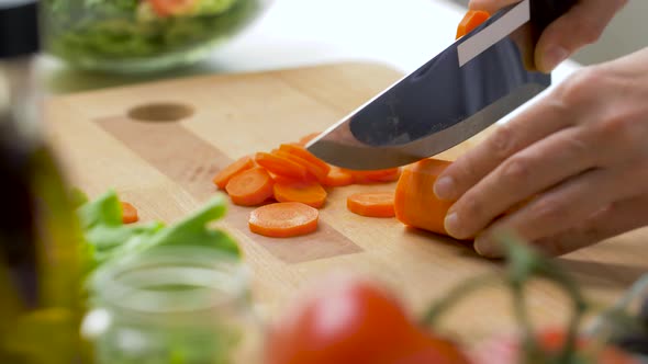 Woman Chopping Carrot with Kitchen Knife at Home