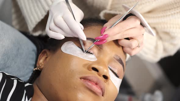 Cosmetologist Doing the Eyelash Extension Procedure on a Woman