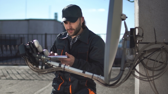 Engineer or Technician Checking an Antennae with Touchpad