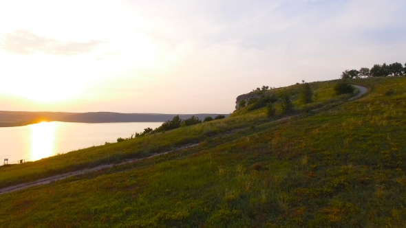 Aerial Shot of a Sunset Near Rocks. Vivid Colors Are Reflected in the Water