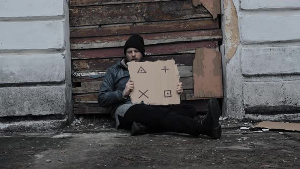 Homeless Man Sits Holds Piece of Cardboard with Markers for Planar Tracking