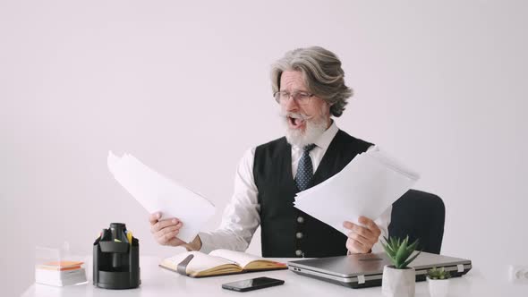 Anxious Older Man Looking at Papers in the Office