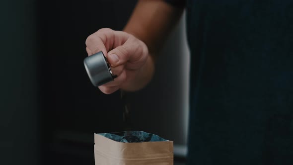 Closeup of Barista hand putting beans in a craft bag in cafe it slow motion closeup with 4k.