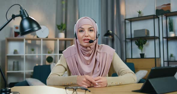 Arabic Woman in Hijab with Headset which Sitting in front of Camera and Records Blog