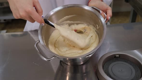 Closeup of a Girl Cook Mixing Dough with a Silicone Spatula in a Metal Bowl