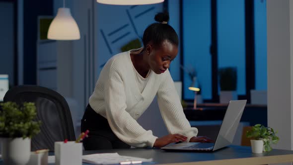 Manager Black Woman Standing at Desk Searching on Laptop and Looking at Camera