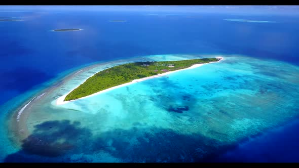 Aerial drone shot panorama of tranquil coastline beach adventure by blue lagoon with white sandy bac