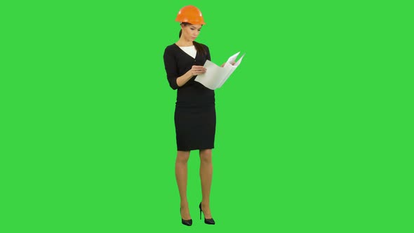 Young Engineer Woman Reading Technical Drawings and Laughing on a Green Screen, Chroma Key