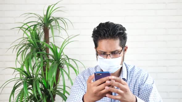 Young Man in Face Mask Using Smart Phone