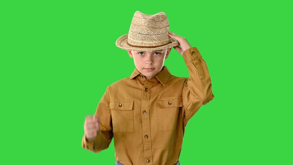 Boy in a Shirt Adjusting His Straw Hat While Walking and Looking at Camera on a Green Screen, Chroma