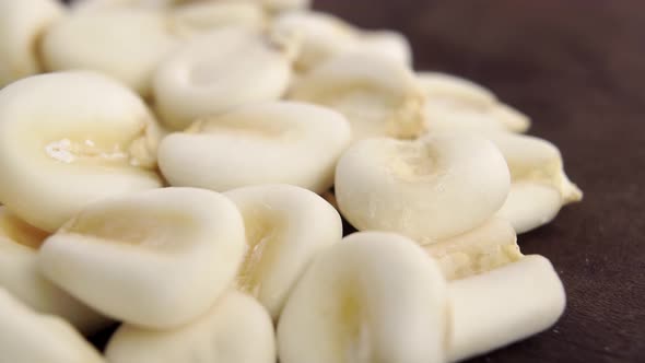 Whole raw hominy. Dry maize mote grain on a rustic board. Macro shot. Rotation