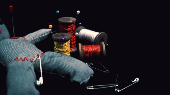 Stitched Voodoo Doll for Ritual on a Black Background with Threads and Needles alt