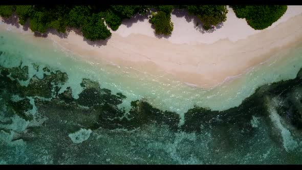 Aerial drone shot panorama of perfect shore beach voyage by blue sea with bright sandy background of