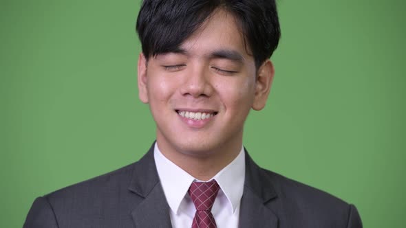 Young Handsome Asian Businessman Relaxing with Eyes Closed