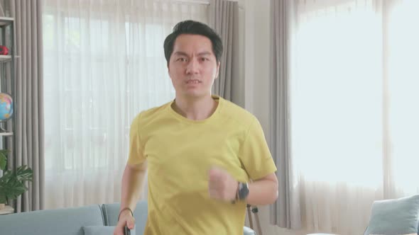 Asian Man Running On A Treadmill At Home