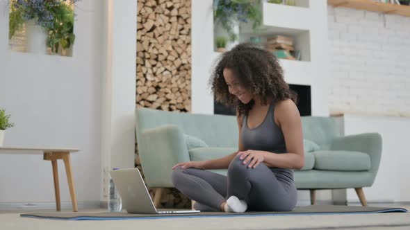 African Woman Talking on Video Call on Laptop on Yoga Mat