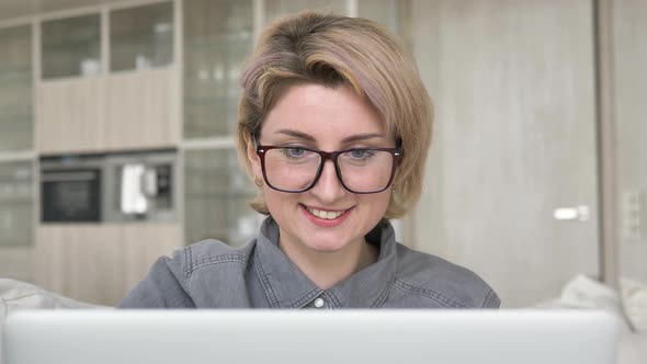 Smiling Blonde Lady Freelancer in Glasses Types on Laptop