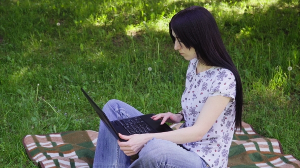 Woman Using Laptop in Park