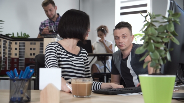 Man and Woman Discussing in Front of Computer