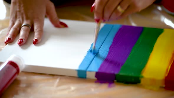 Close up of woman painting stripes on a canvas