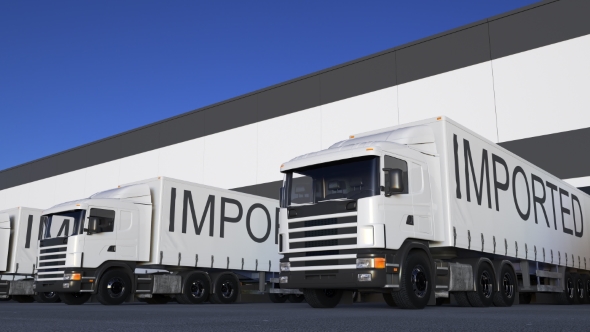 Speeding Freight Semi Truck with IMPORTED Caption on the Trailer Loading or Unloading alt