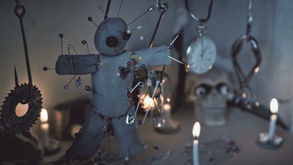 the Voodoo Doll Swinging on the Hook Over the Ritual Table alt