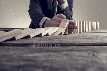 n stopping domino effect on wooden table. Business solution concept.