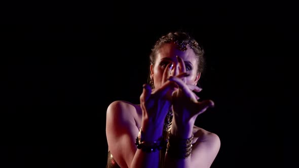 Closeup of a Woman Who Dances an Oriental Dance on a Black Background Makes Beautiful Movements with