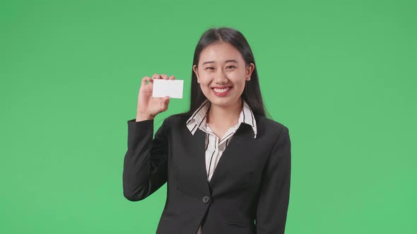 Asian Business Woman With Smile Holding A White Card While Standing In Front Of Green Screen