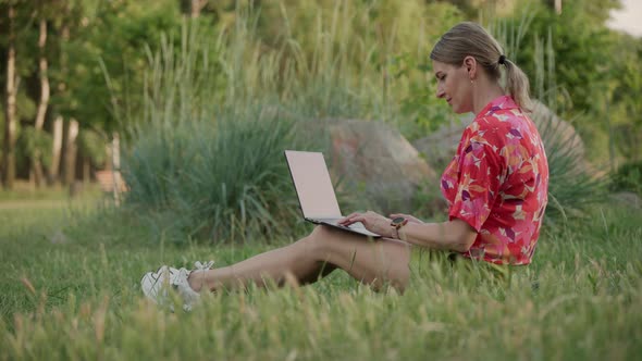 A Middleaged Woman Works Using Her Laptop in a Public Park