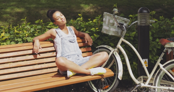 Woman Enjoying Sun on Bench in Park