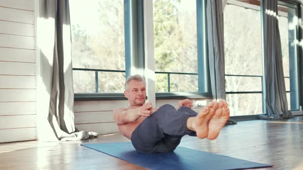 Mature Man Amongst Doing Power Yoga Exercises